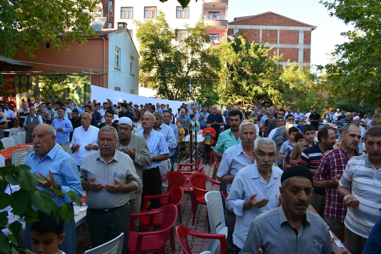 Anma programında dua eden topluluk